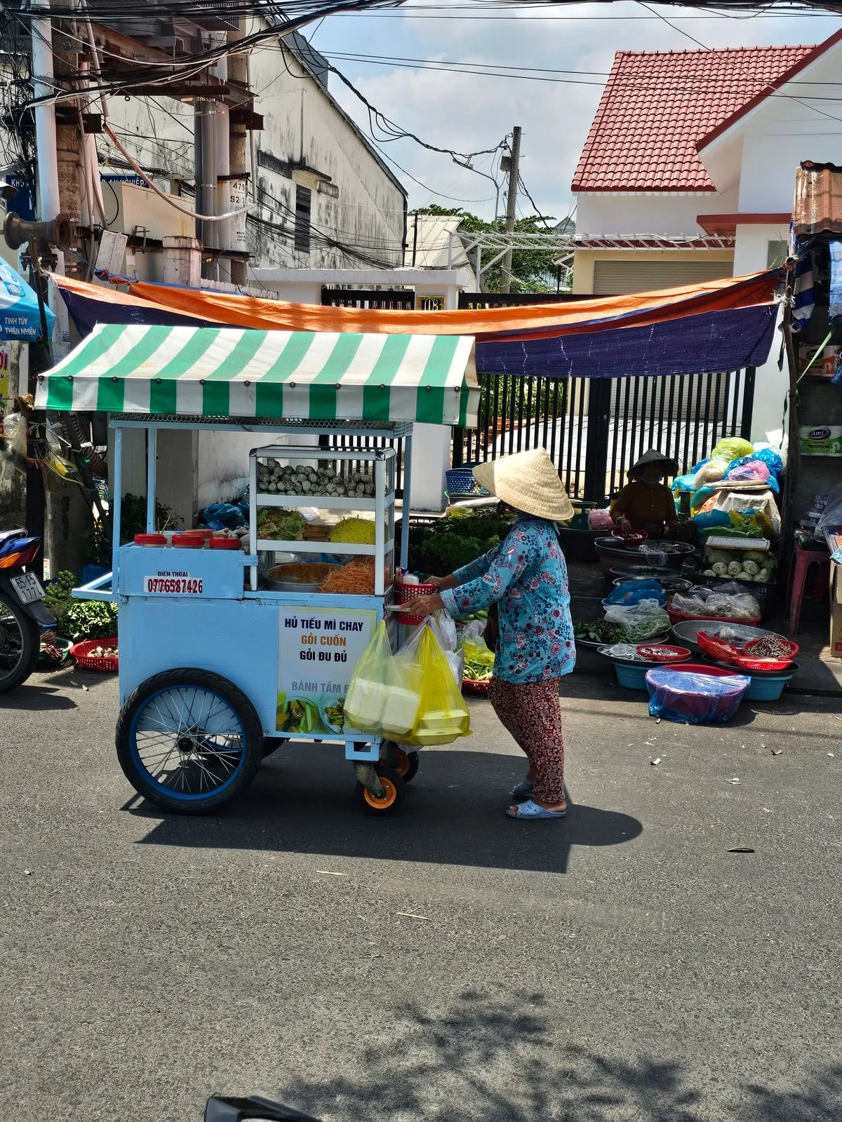 Vendedor ambulante empurrando carrinho de frutas em rua movimentada